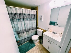Un baño con inodoro, lavamanos y espejo.