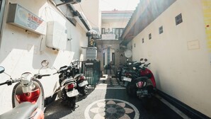 A narrow alley with parked motorcycles and scooters. - Samudra Homestay (Kuta)