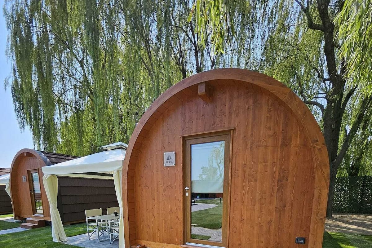 A wooden cabin with a curved entrance and a small porch area.