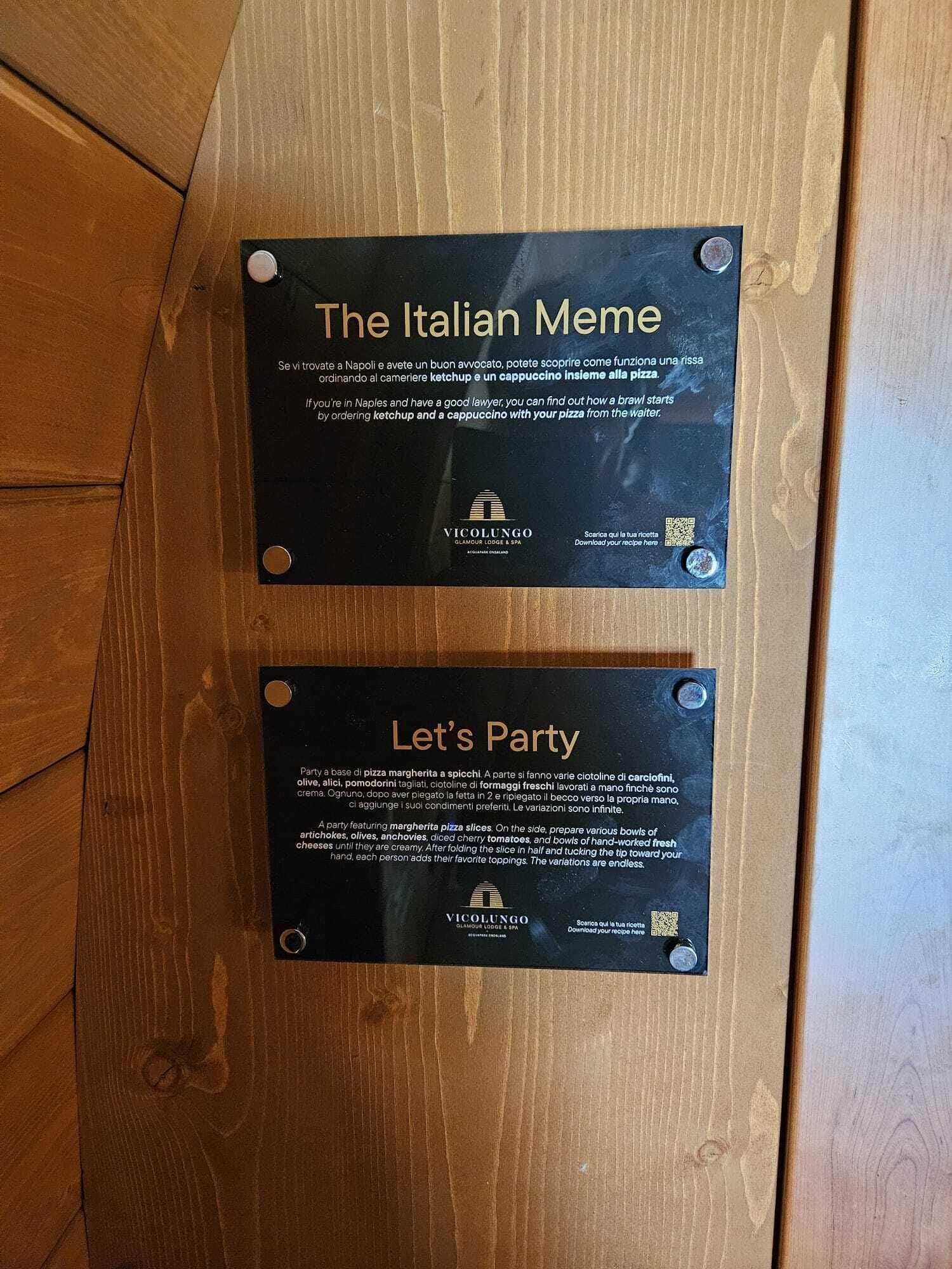 Deux plaques noires, fixées sur une surface en bois, comportant du texte et des codes QR.
