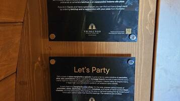 Two black plaques on a wooden surface with text and QR codes.