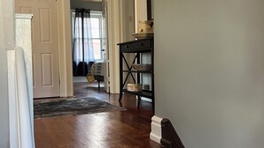 Una escalera conduce a un segundo piso con acabado de madera oscura y un rellano alfombrado en gris.