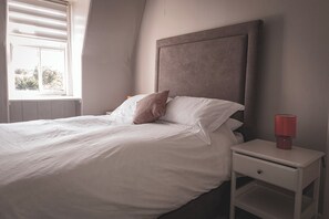Cozy retreat with a neatly made bed and a comfortable nightstand.