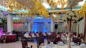 A banquet hall with round tables, red chairs, and white tablecloths. - Fiesta Ballroom Hotel (Legazpi)