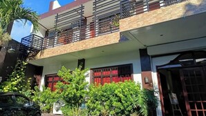 A two-story building with a balcony on the upper floor, surrounded by greenery. - Fiesta Ballroom Hotel (Legazpi)