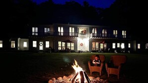 Una casa espaiosa amb un foc al pati davanter, dues cadires de vimetla i una entrada ben il·luminada.