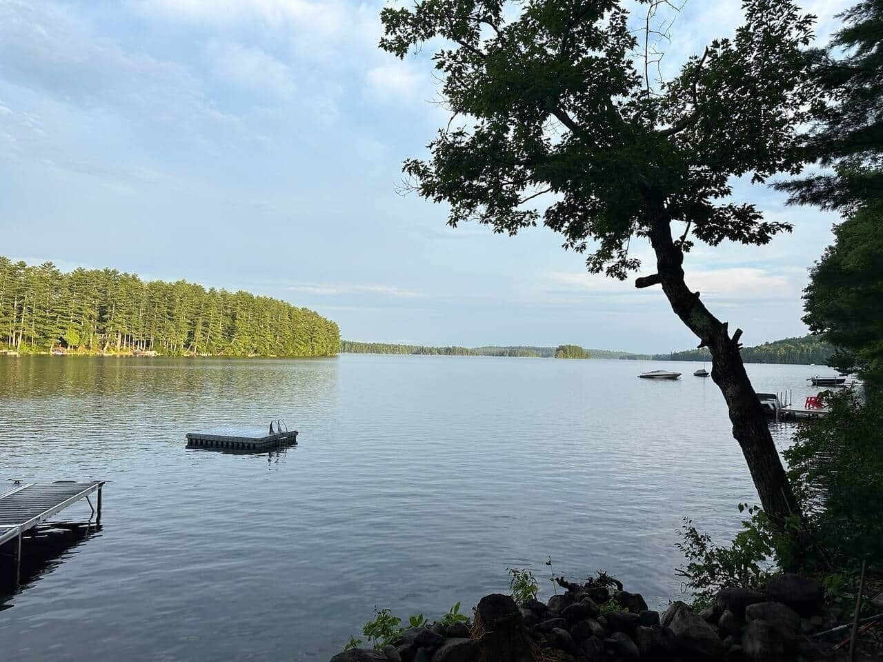 A calm lake with a dock and a small boat.