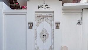 Un edificio blanco con una puerta decorativa que dice 'Villa Eléa'.