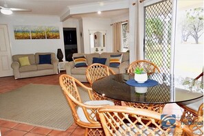 Relax in this inviting living space with a sofa set, wicker chairs, and a large rug.