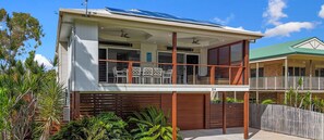 Relax on the spacious balcony with a beautiful view of lush greenery, including palm trees and ferns.