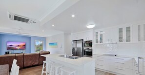 Enjoy cooking and relaxing in this kitchen with a central island, sink, and flat-screen TV.