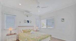 Cozy retreat with a single bed, floral bedspread, and ceiling fan.