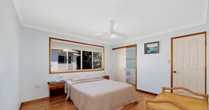 Cozy retreat with a single bed, ceiling fan, and bedside table.