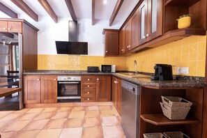 A kitchen with wooden cabinets, a built-in oven, a microwave, and a dishwasher.