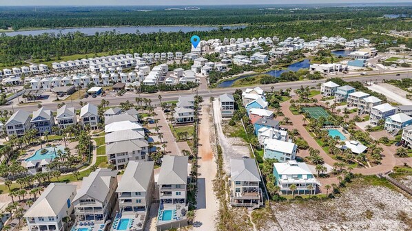 A coastal residential area with multiple two-story houses, a central road, and a beach.