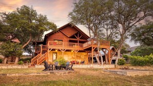 Eine Holzblockhütte mit Balkon, Sitzgelegenheit im Freien und einem Feuerkorb.