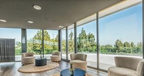A modern interior with large windows, a round coffee table, and two armchairs. - Marisol | Sea view - pool - gym (Mijas Costa)