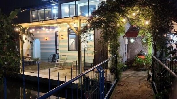 A modern house with a glass facade, a covered patio, and a small pond. - Villa Gunung Bhakti (Cipanas)