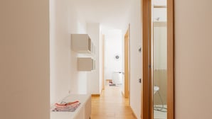 A hallway with a radiator, a door leading to a bathroom, and a clock on the wall. - GuestHost - Beautiful 35 sqm apartment located on the mezzanine floor of a building WITHOUT elevator (stairs to access it). The property is located 11 minutes by public transport from City Life, the largest pedestrian area in Milan, and from MiCo, the la (Milano)