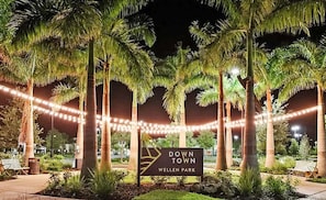 A sign for 'Down Town Wellen Park' with palm trees and string lights. - Luxurious 4BR in Wellen Park - Pool home - Golf  membership included - Florida Sanctuary (Venice)