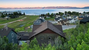 Un barrio residencial con casas, un sendero y vistas a un lago y montañas.