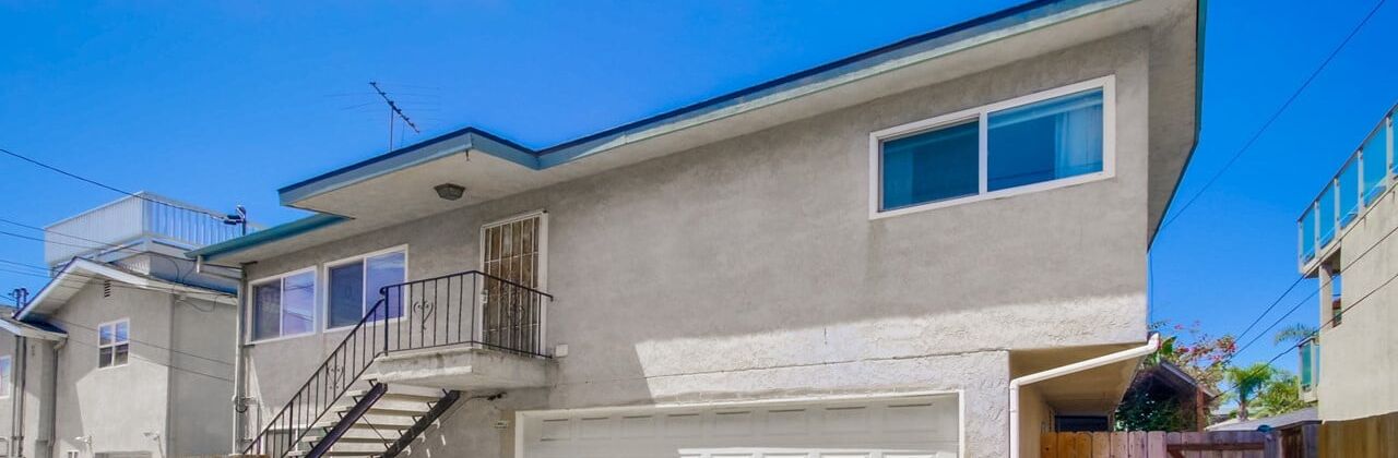 A two-story house with a garage, a balcony, and a visible satellite dish.