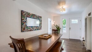 Un comedor con una mesa de madera, sillas y un espejo decorativo en la pared.