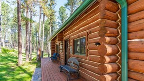 A log cabin with a porch, a bench, and a window. - Pine Cabin- Log cabin close to Custer (Custer)