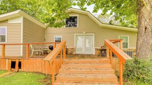 A wooden staircase leading to a house with a front porch, a small deck, and a window above the door. - Greers Ferry Home w/ Fire Pit Near Shiloh Marina! (Greers Ferry)