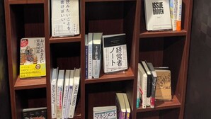 Una estantería con varios libros y algunos artículos promocionales.