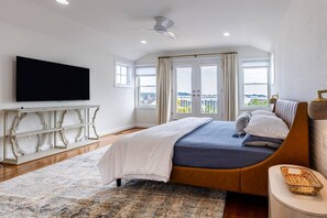 A bedroom with a bed, a television, a ceiling fan, and a view of the outdoors. - All Newly-Designed Water Views, Expansive Yard, Steps to Restaurants and Downtown Annapolis (Annapolis)