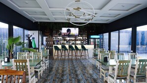 A restaurant with a bar area, wooden chairs, and a television screen. - Ketrin Hotel & Restaurant (Masis)