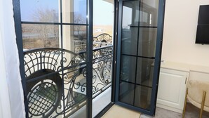 A room with a sliding glass door leading to a balcony with a wrought iron railing. - Ketrin Hotel & Restaurant (Masis)