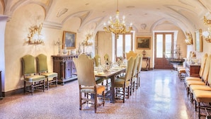 A formal dining room with a long table set for multiple guests, flanked by ornate chairs and a chandelier. - Villa Margaret: A splendid nineteenth-century three-story historical villa surrounded by the greenery, with Free WI-FI. (Pontremoli)