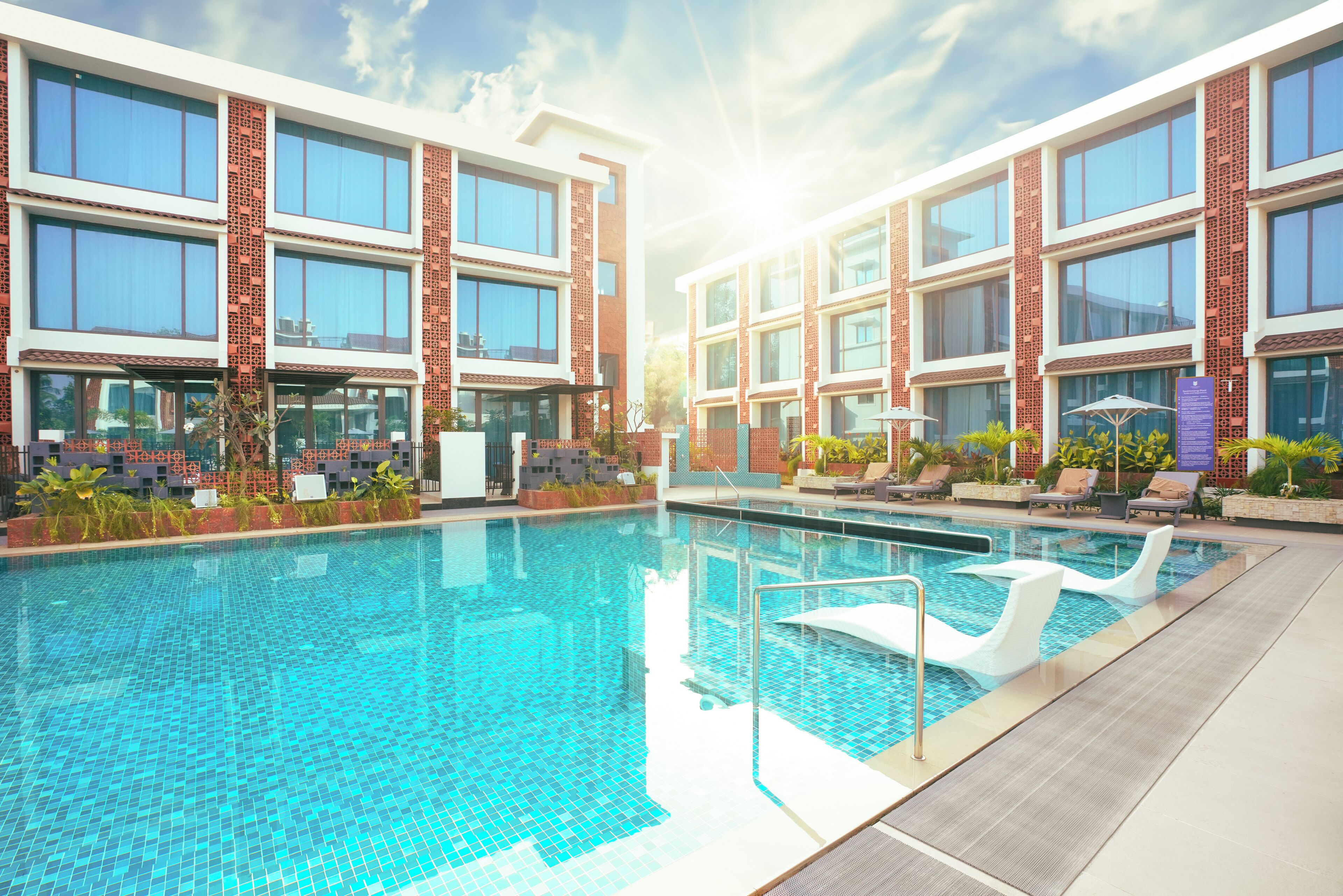 Una piscina al aire libre, sombrillas, tumbonas