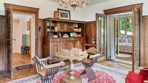 A room with a wooden bookcase, a chess table, and a chandelier. - Apartment 'Villa Stumm' with Mountain View, Shared Terrace and Wi-Fi (Stumm)