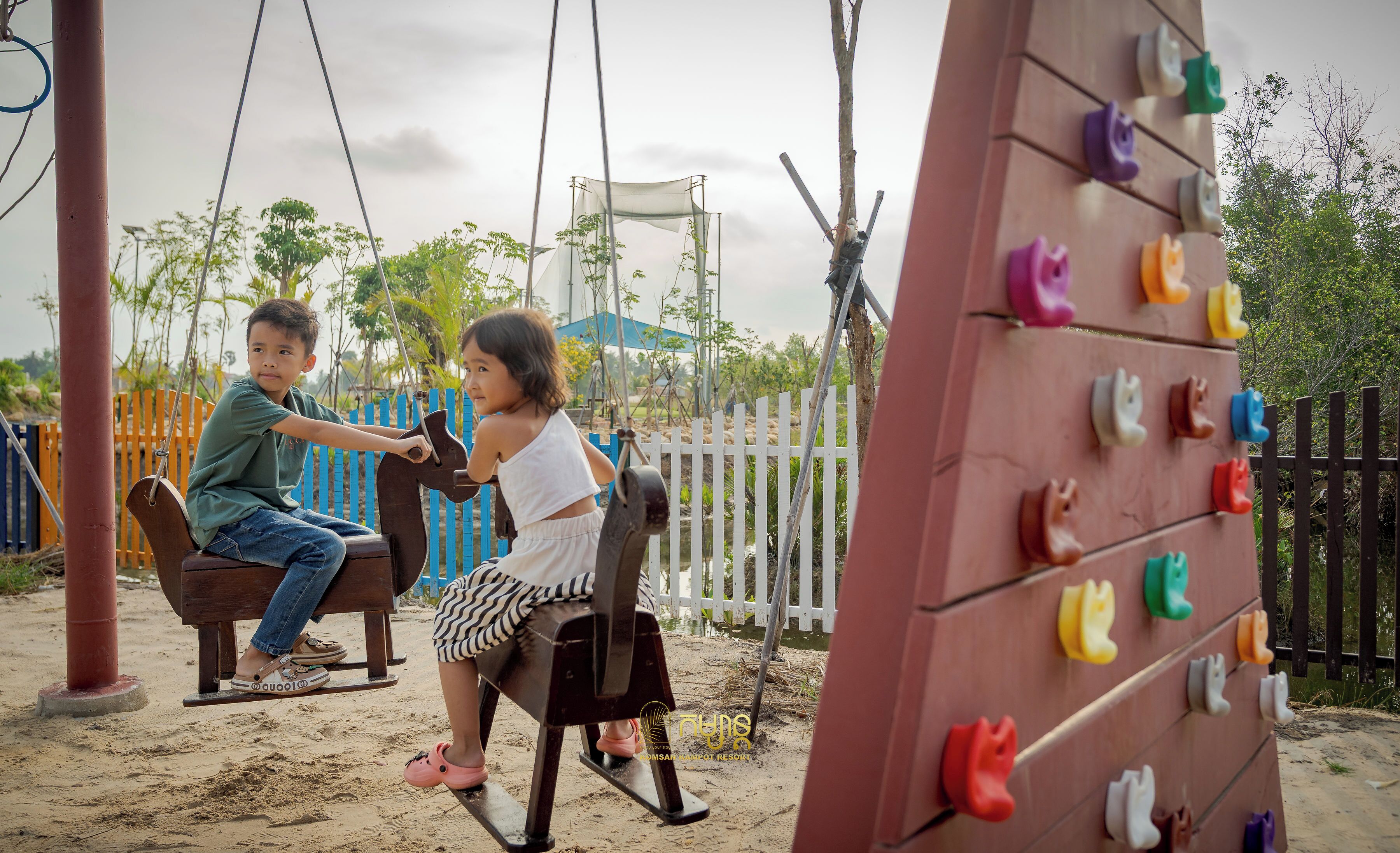 A playground with swings and a climbing wall.
