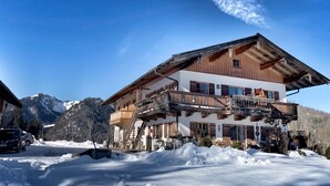 A chalet-style hotel with a wooden facade, balconies, and a mountain backdrop. - Apartment 'Ferienwohnung Unternberg' with Mountain View, Shared Terrace and Wi-Fi (Ruhpolding)
