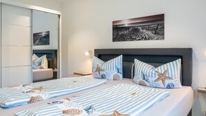 Una habitación de hotel con cama, mesita de noche, espejo e imagen colgada en la pared.