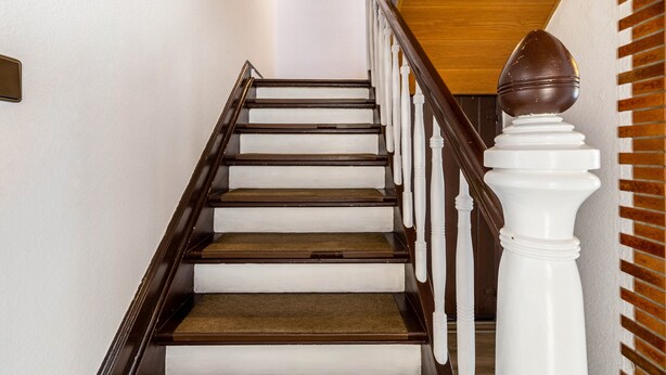 A wooden staircase with white balusters and a white balustrade. - Holiday Home 'Lichtblick' with Private Terrace, Shared Garden, and Wi-Fi (Bottrop)
