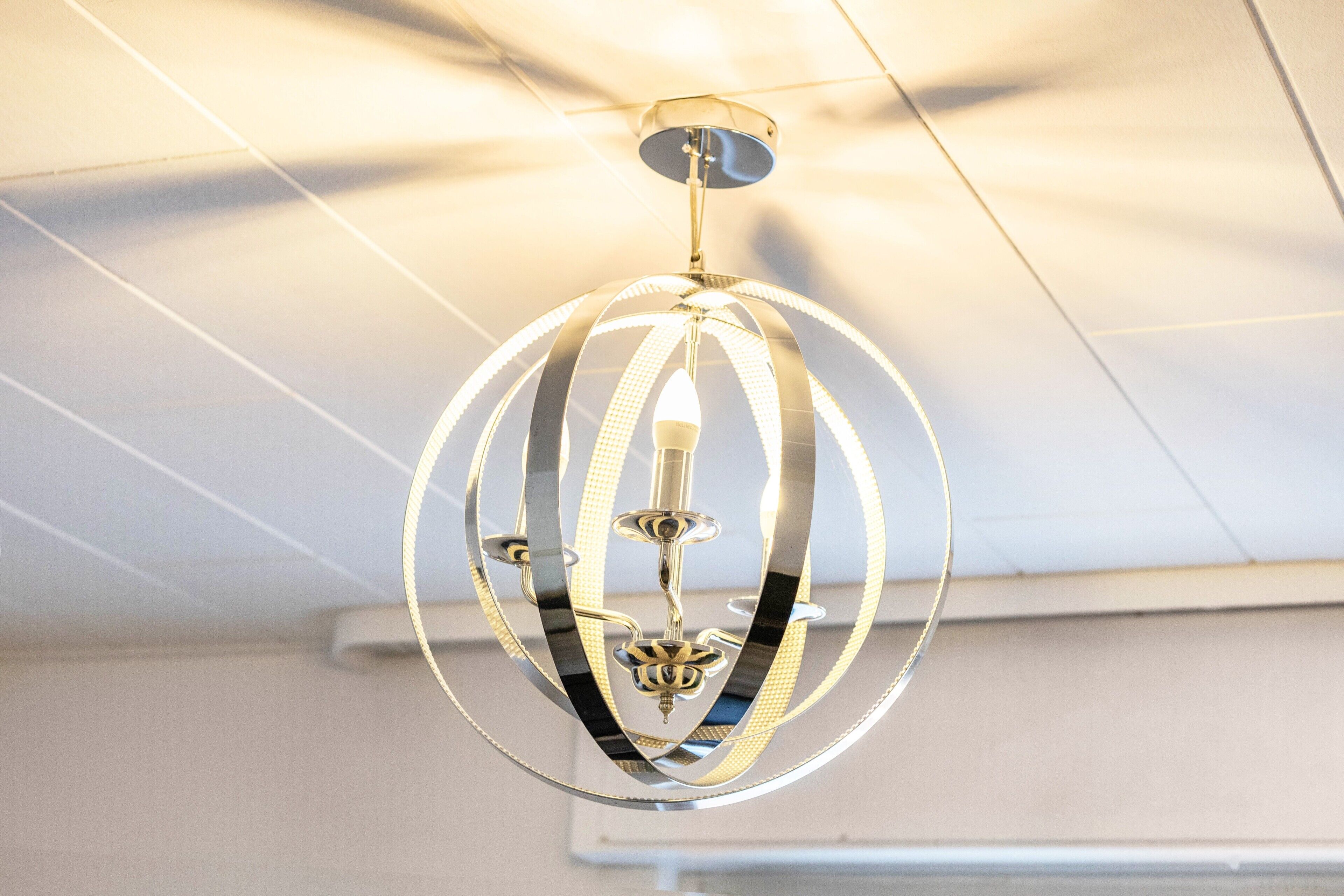 Ein moderner Kronleuchter mit sphärischem Design und einer zentralen Lichtquelle.