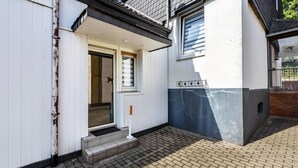 A building with a white exterior, a visible entrance, and a brick-paved ground. - Holiday Home 'Lichtblick' with Private Terrace, Shared Garden, and Wi-Fi (Bottrop)
