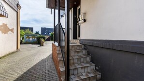 A building with a staircase leading to a covered area, a wall with a fish mural, and a clear sky. - Holiday Home 'Lichtblick' with Private Terrace, Shared Garden, and Wi-Fi (Bottrop)