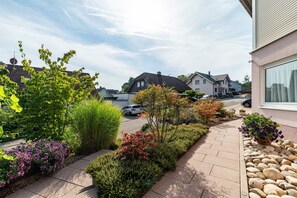 A residential street with houses, a paved sidewalk, and various plants. - Apartment ''Kraichgau-Nest'' with Private Terrace and Wi-Fi (Reichartshausen)