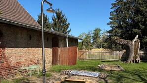 A backyard with a wooden pool, a metal lamp post, a brick building, and a wooden fence. - Guesthouse 'Schlamau19 - Under the Walnut Tree'
Apartment with 2 Guest Rooms, Shared Kitchen and Garden (Wiesenburg/Mark)