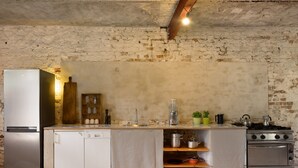 A kitchen with a refrigerator, dishwasher, sink, stove, and various kitchen items. - Guesthouse 'Schlamau19 - Under the Walnut Tree'
Apartment with 2 Guest Rooms, Shared Kitchen and Garden (Wiesenburg/Mark)