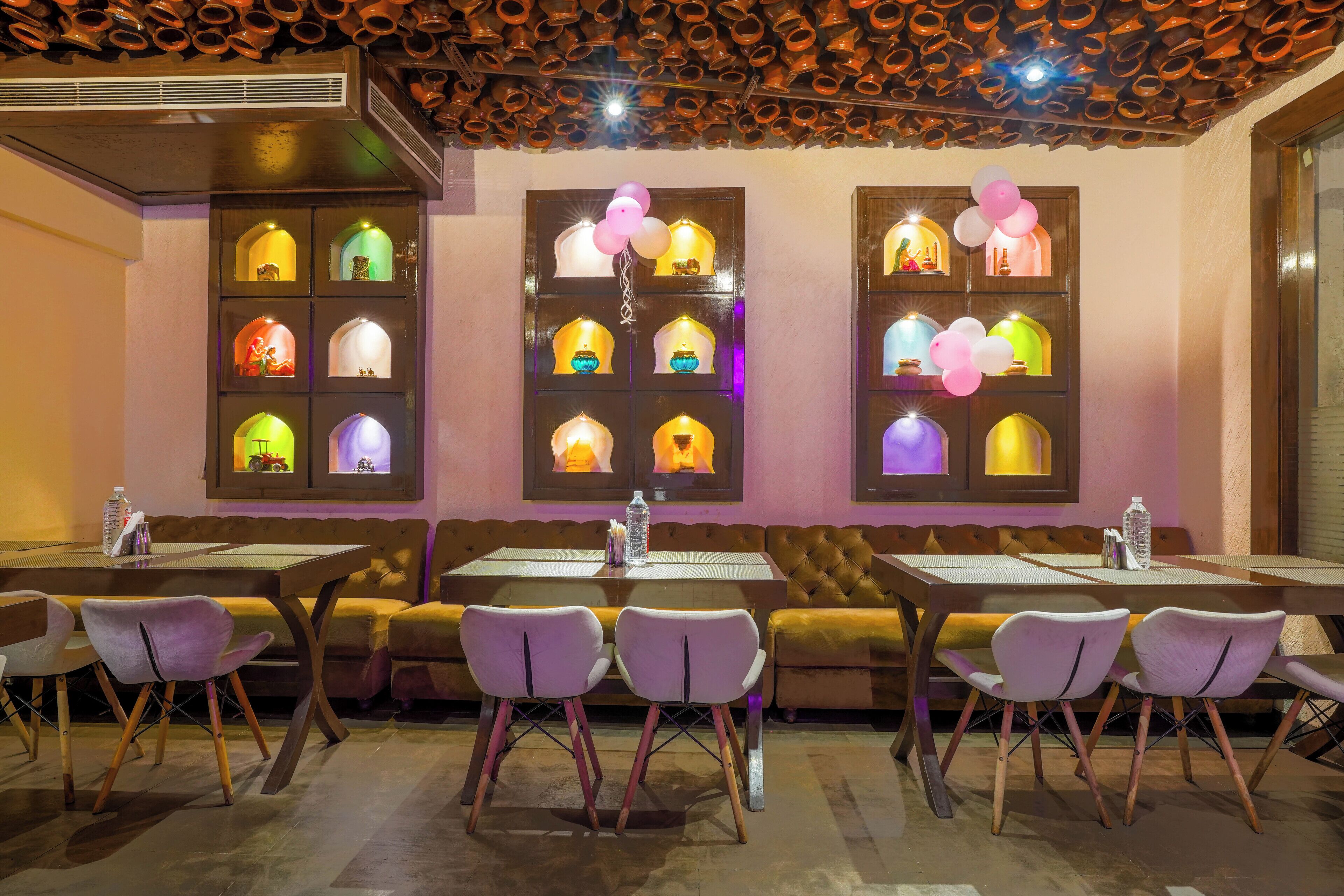 A restaurant with booths and tables, each with a unique illuminated window display.
