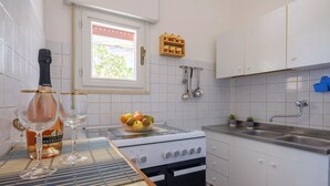 Uma cozinha com fogão, pia e armários.