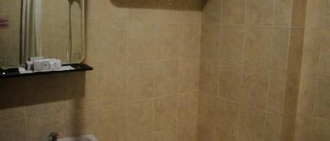 A bathroom with a sink, mirror, shower, and towel rack.