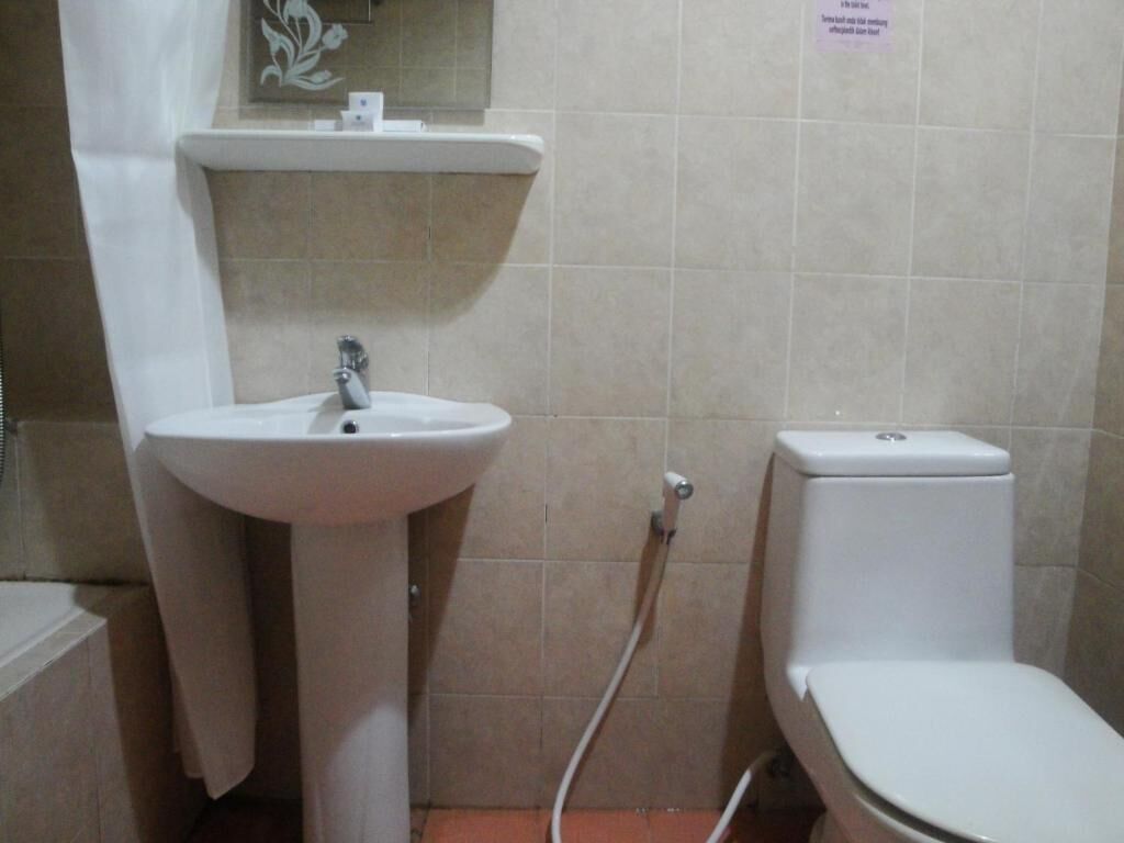 A small bathroom with a sink, toilet, and a towel hanging on the wall.
